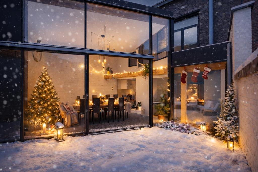 ein Haus mit einem Weihnachtsbaum im Schnee in der Unterkunft Townhouse Tongeren Center 275m2, 10p - Featured in Designbook in Tongeren