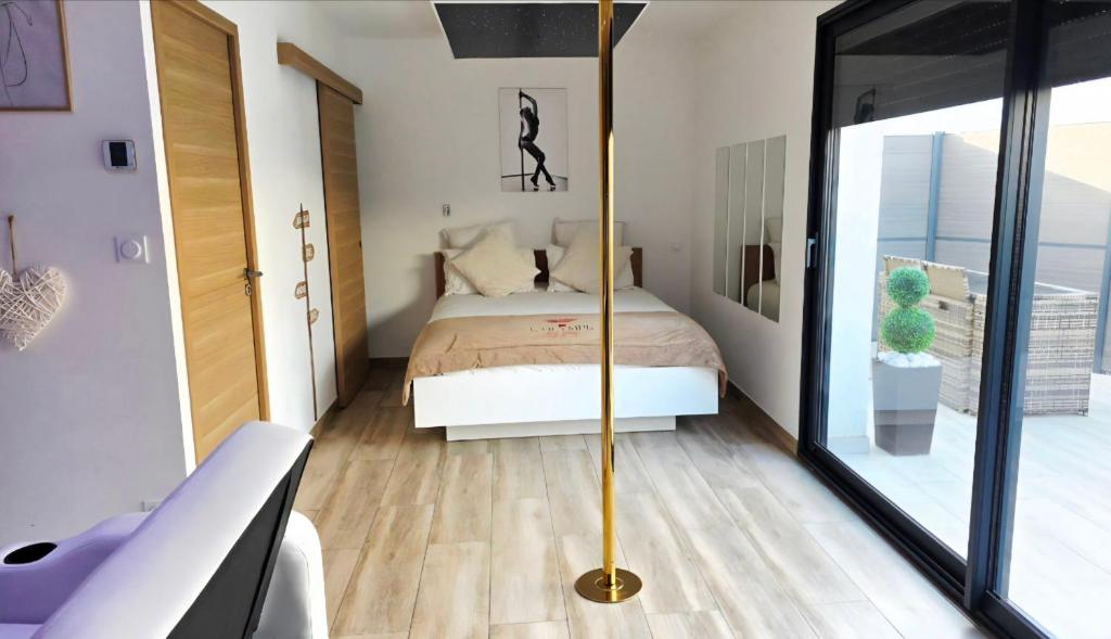 a bedroom with a bed and a large glass window at L'OLYMPE DES SENS in Portiragnes
