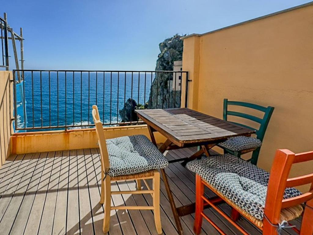 einen Holztisch und Stühle auf einem Balkon mit Meerblick in der Unterkunft Il Sogno di Beatrice Luxury Apartment with Views in Manarola