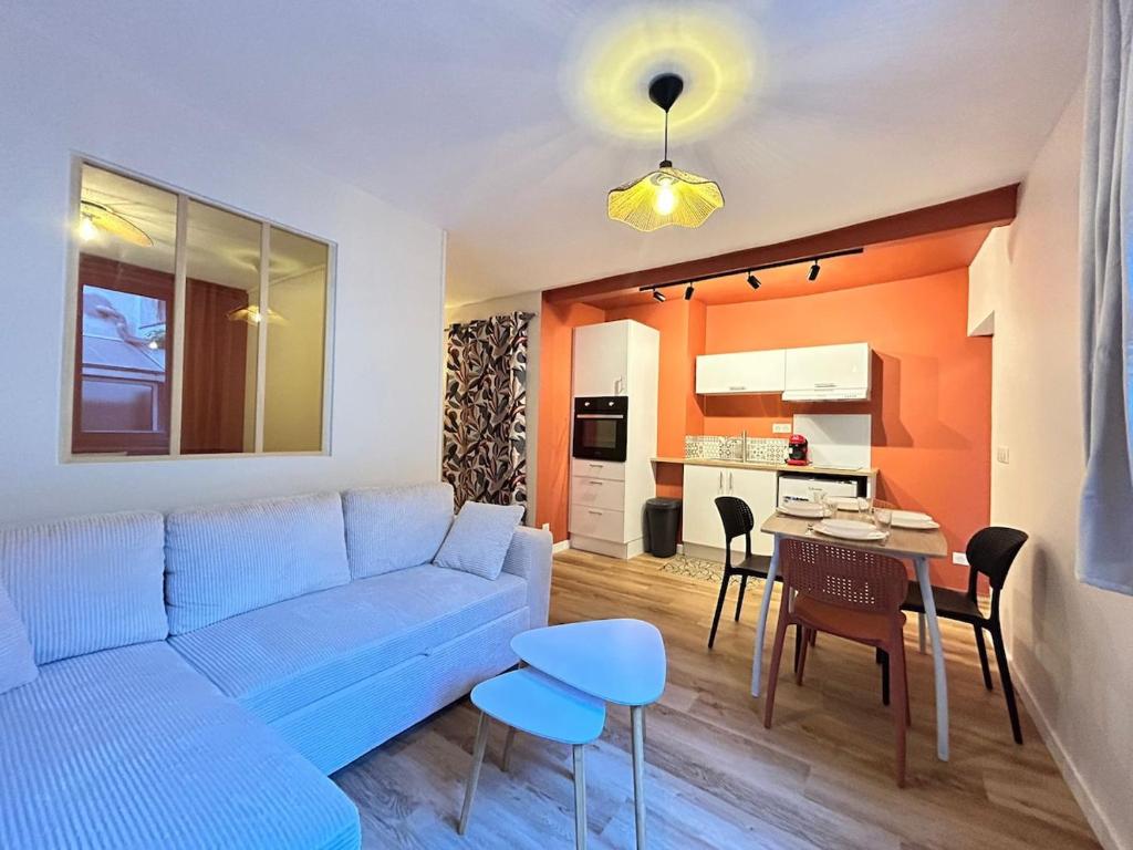 un salon avec un canapé bleu et une table dans l'établissement Le Terracotta, central et intimiste, à La Celle-sous-Gouzon