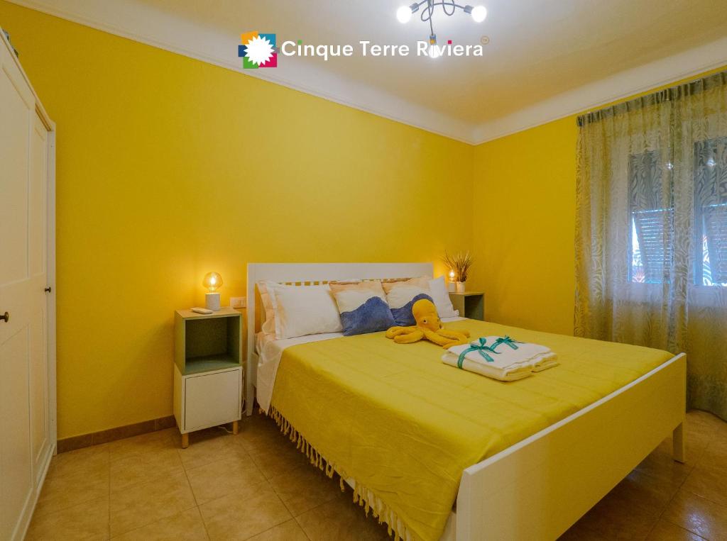 una camera da letto con un letto con una parete gialla di Ca' Bea Apartment with AC and Terrace a Vernazza