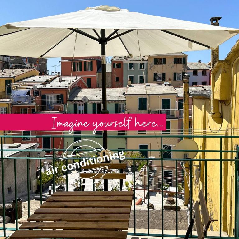 an umbrella and stairs with a city in the background at Ca' Bea Apartment with AC and Terrace in Vernazza