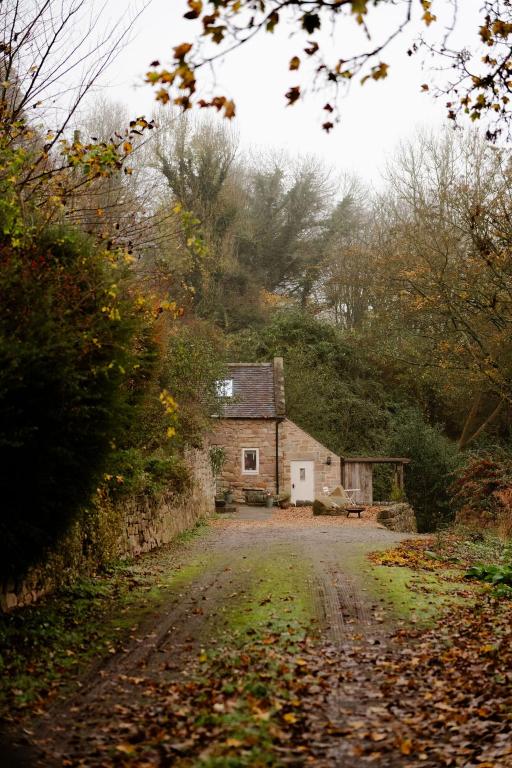 una vecchia casa sul ciglio di una strada sterrata. di Bramble & Stone Escapes- The Barn a Highpeak Junction