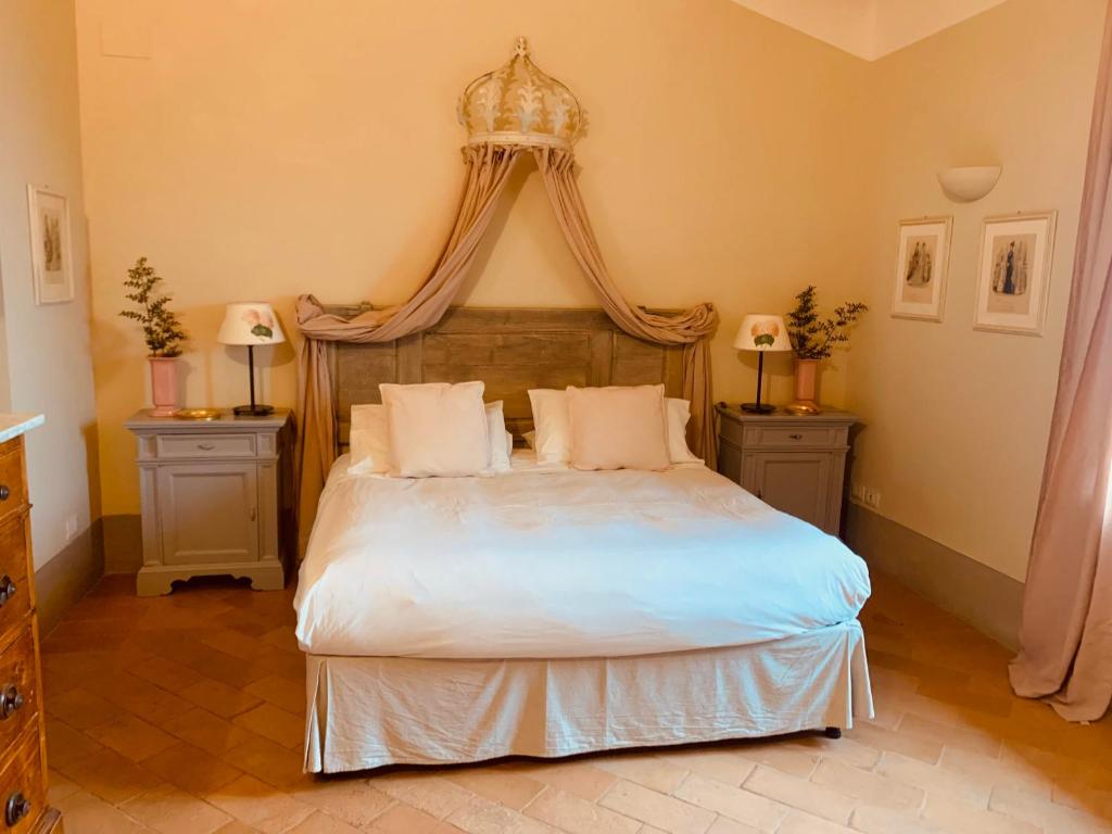 una camera da letto con un grande letto a baldacchino di Borgo Montefreddo Toscana a San Casciano dei Bagni