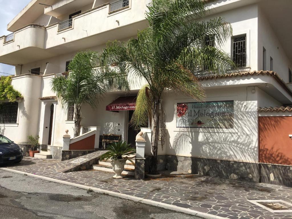 濱海尼可泰拉的住宿－Il Melograno，前面有棕榈树的建筑