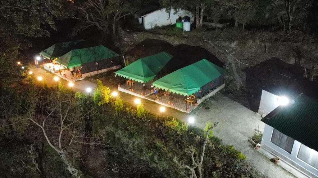 een bovenaanzicht van een feesttent 's nachts bij the jungle book - luxury camps by lake & woods in Bhīm Tāl