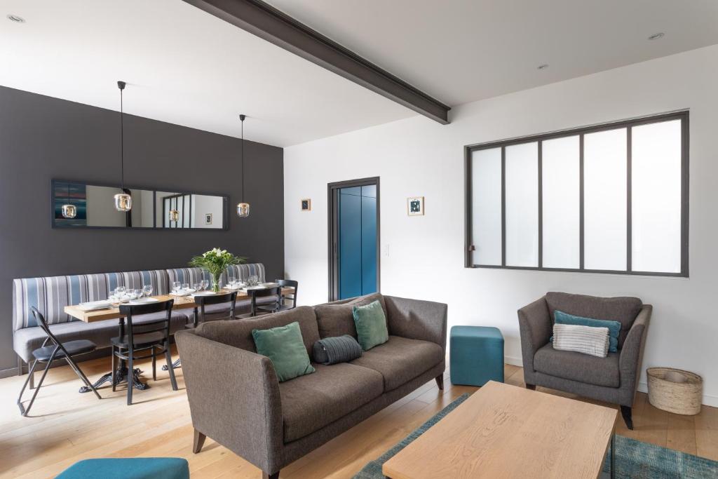 ein Wohnzimmer mit Sofa und Tisch in der Unterkunft Le Rock Fish - Quelques minutes de la plage in Dinard