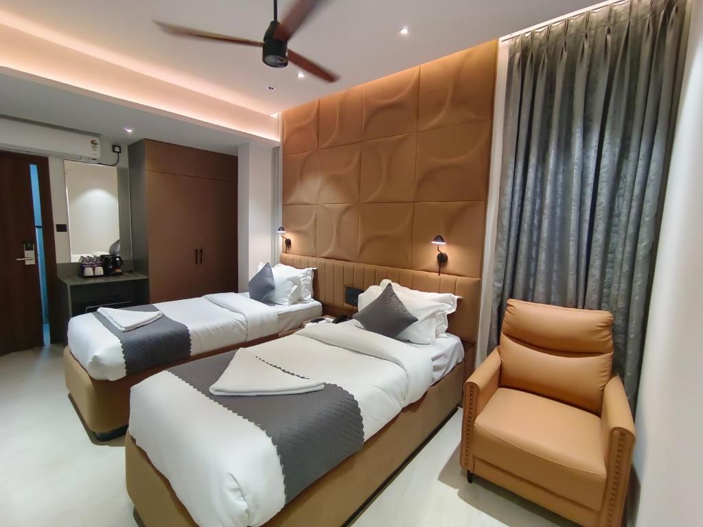 ein Hotelzimmer mit zwei Betten und einem Stuhl in der Unterkunft 23 Urban Suites, Hitech City in Hyderabad