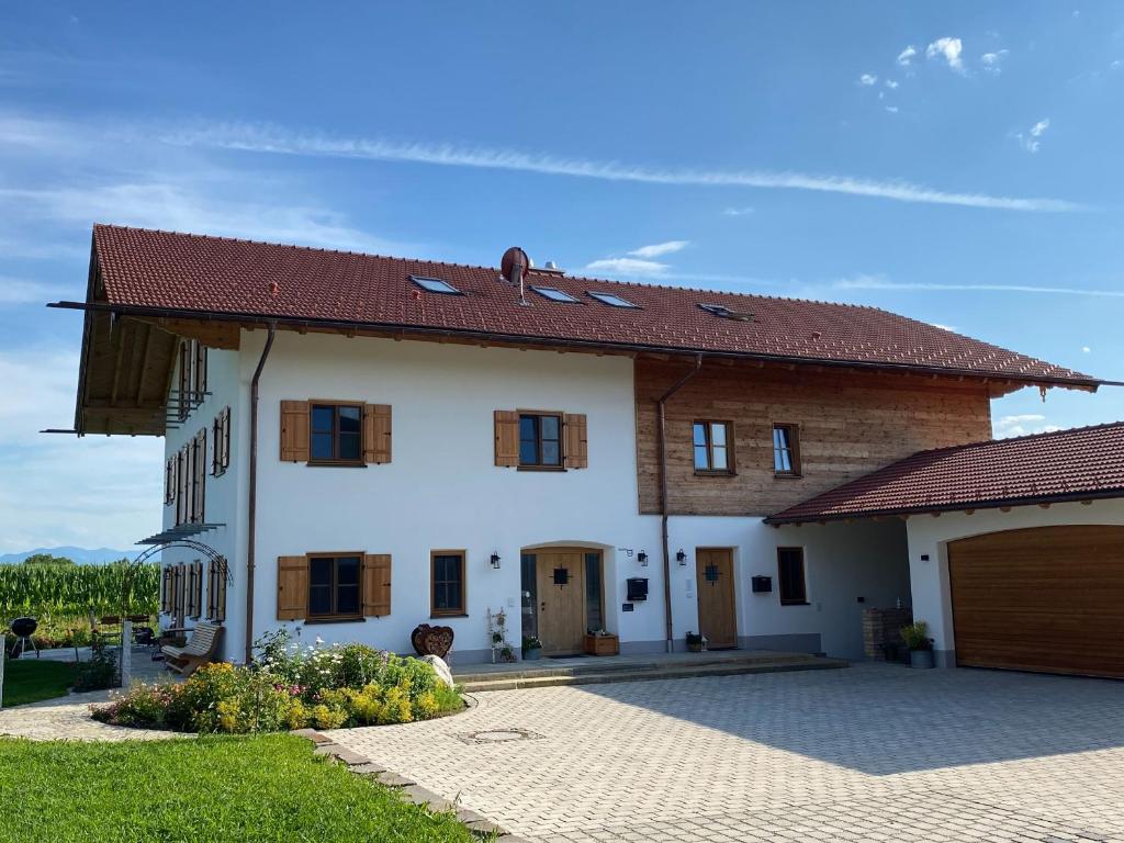 a white house with a brown roof and a garage at Eberlhof in Schechen