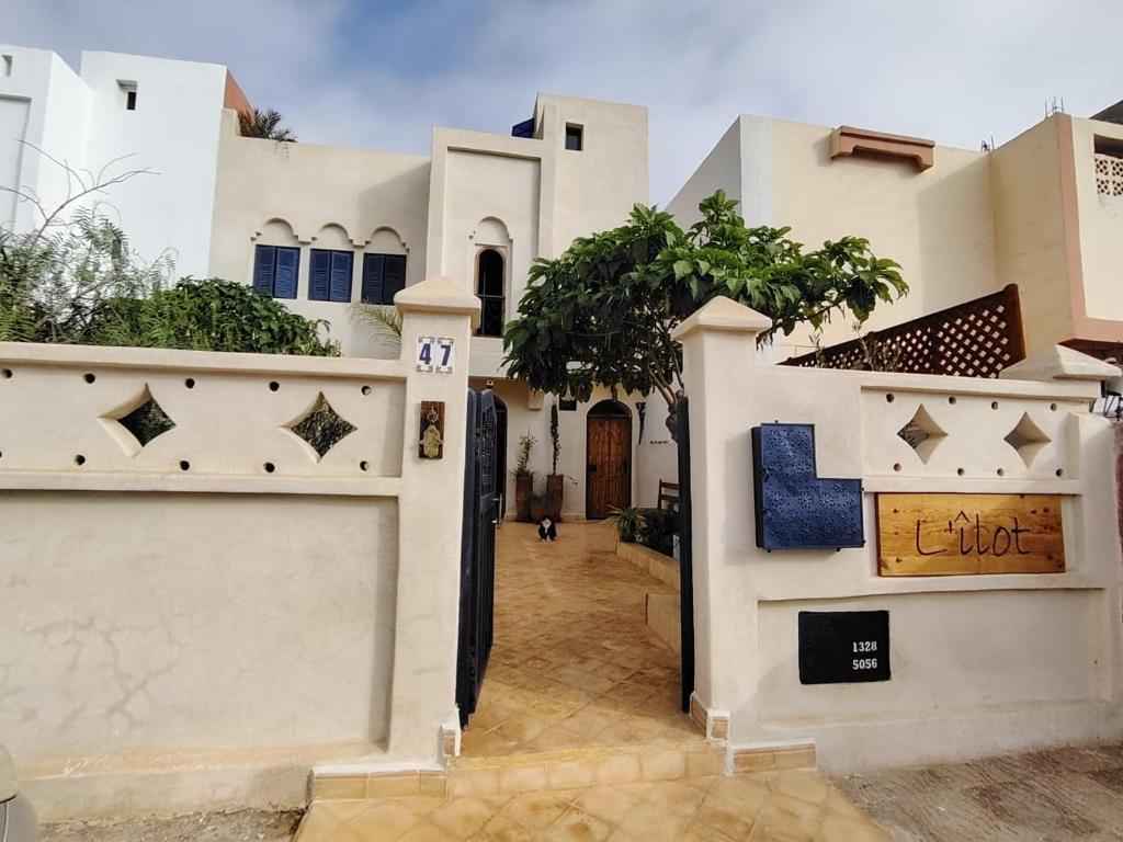 een wit huis met een hek en een hek bij L'îlot in Sidi Ifni