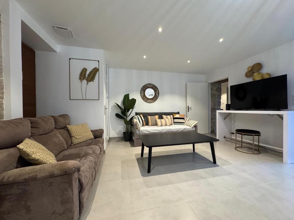 ein Wohnzimmer mit Sofa und Tisch in der Unterkunft Le Kandinsky, moderne et spacieux in La Celle-sous-Gouzon