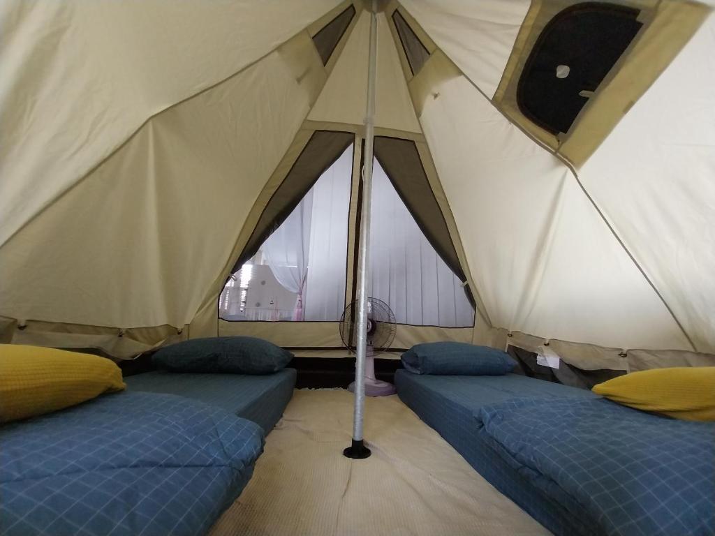 a tent with two beds in it with a window at To The Moon Guesthouse in Chiang Mai