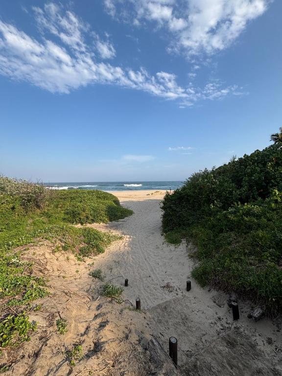 a sandy beach with the ocean in the background at Sting-ray Cottage in Port Edward