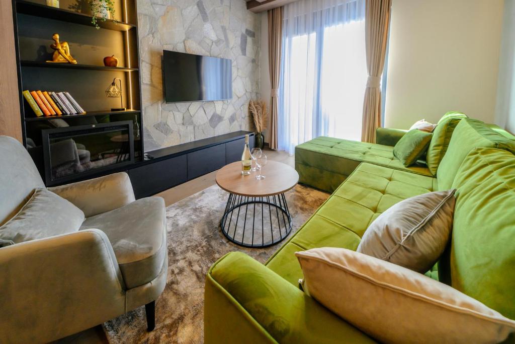 a living room with a green couch and a table at Zlatibor Pine & Peak in Zlatibor