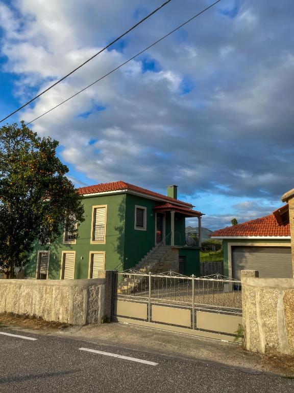 a green house on the side of a street at Casa do Barbosa in Monção