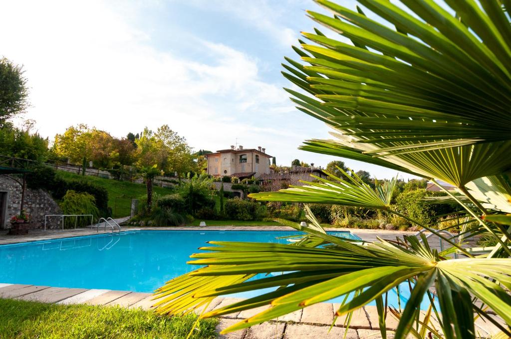 a view of a swimming pool with a house in the background at Bagode Country Lodge in Desenzano del Garda