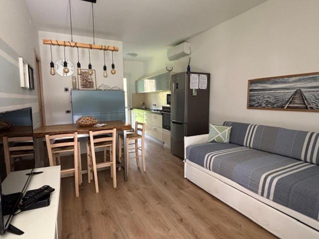 a living room with a couch and a table and a kitchen at Villaggio Michelangelo in Bibione