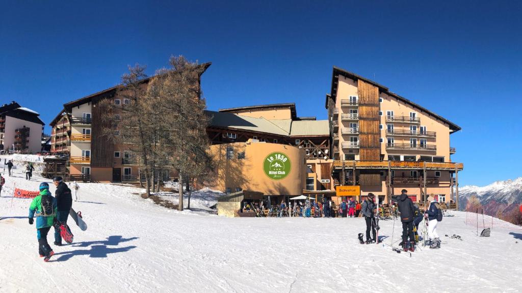 een groep mensen die in de sneeuw voor een skihut staan bij Hôtel Club Le 1850 Risoul in Risoul