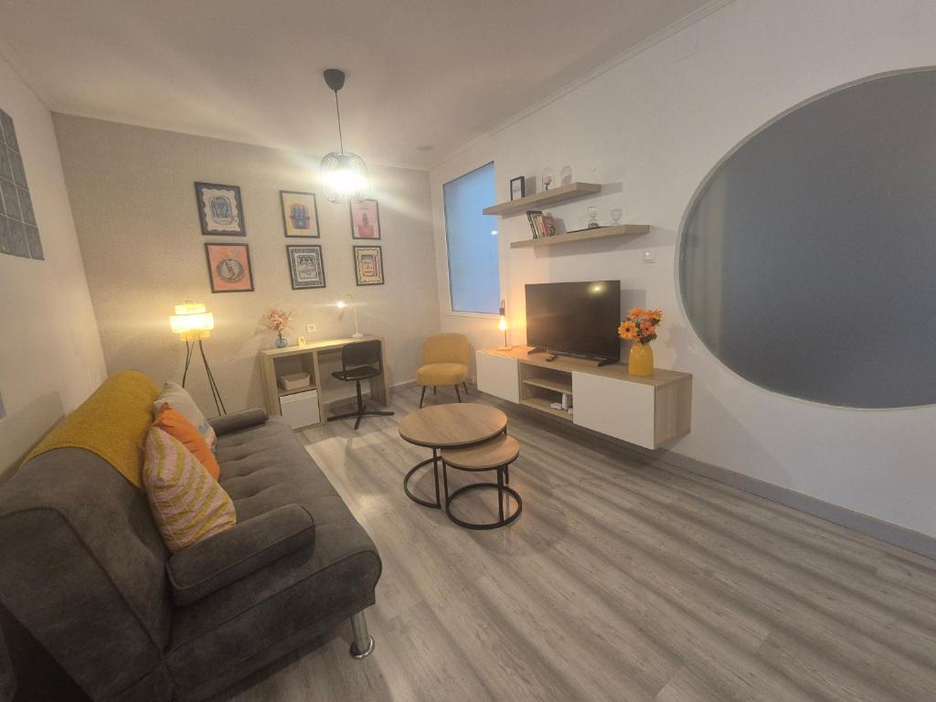 Una sala de estar con un sofá y un televisor. en 659A by R2R Apartmento céntrico para 3 personas, en Oviedo