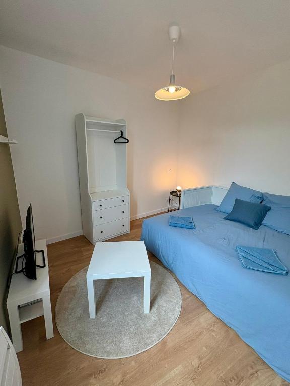 a bedroom with a blue bed and a white table at Azur 2 - Gare de Roubaix in Roubaix
