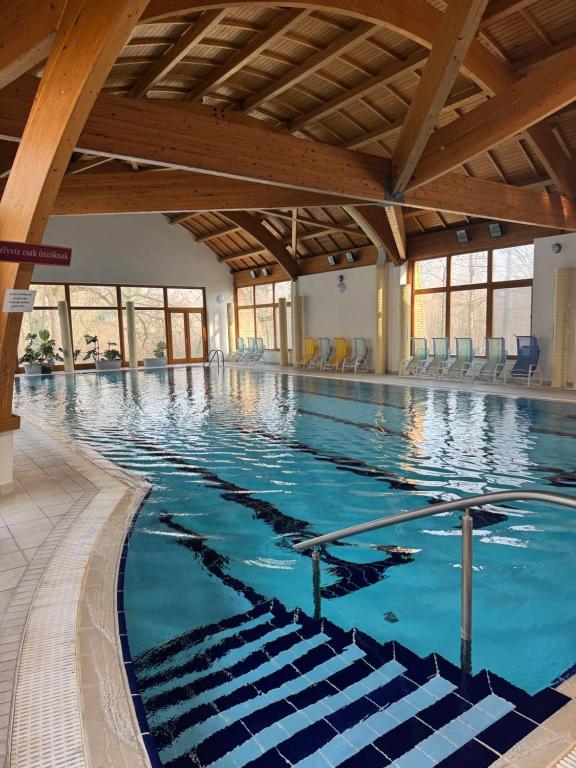 een groot overdekt zwembad met blauw water bij Thermal Hotel Tengelic 