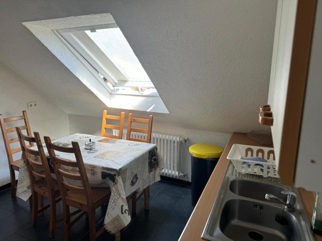 eine Küche mit einem Tisch mit Stühlen und einem Dachfenster in der Unterkunft GMA Apartment H26 in Mahlberg