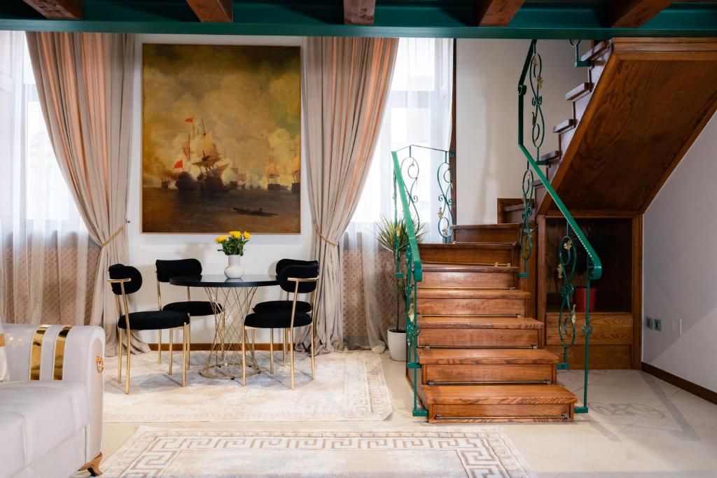 a living room with a staircase and a table and chairs at Baroque Residence in Timişoara