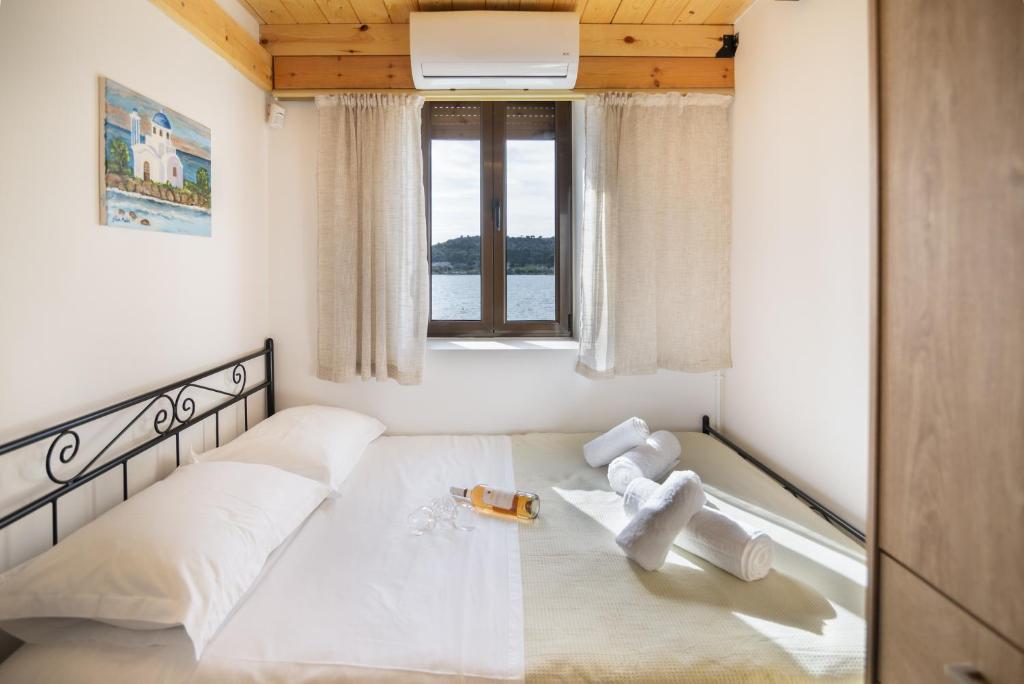 a bedroom with a large white bed with a window at Seaside Stone Retreat in Salamina