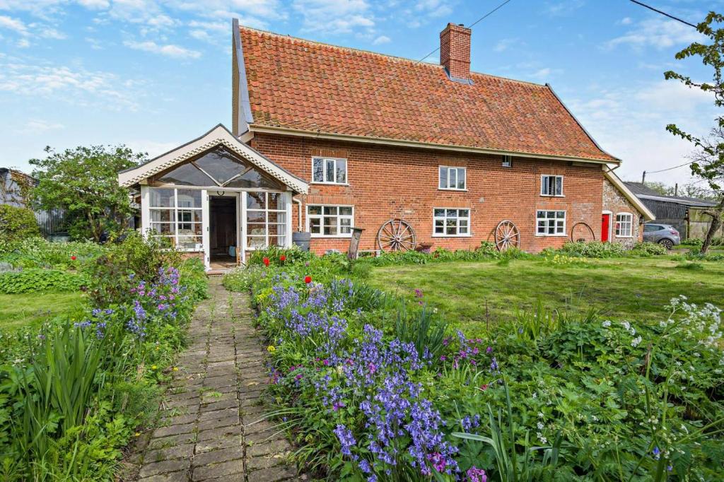 a brick house with flowers in front of it at 3 Bed in Rumburgh oc-c27094 in Rumburgh