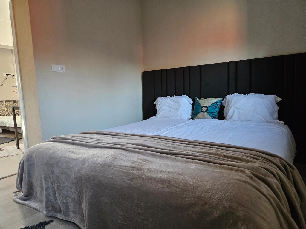 a large bed with a black headboard in a bedroom at Jois Apartments Periam in Periam