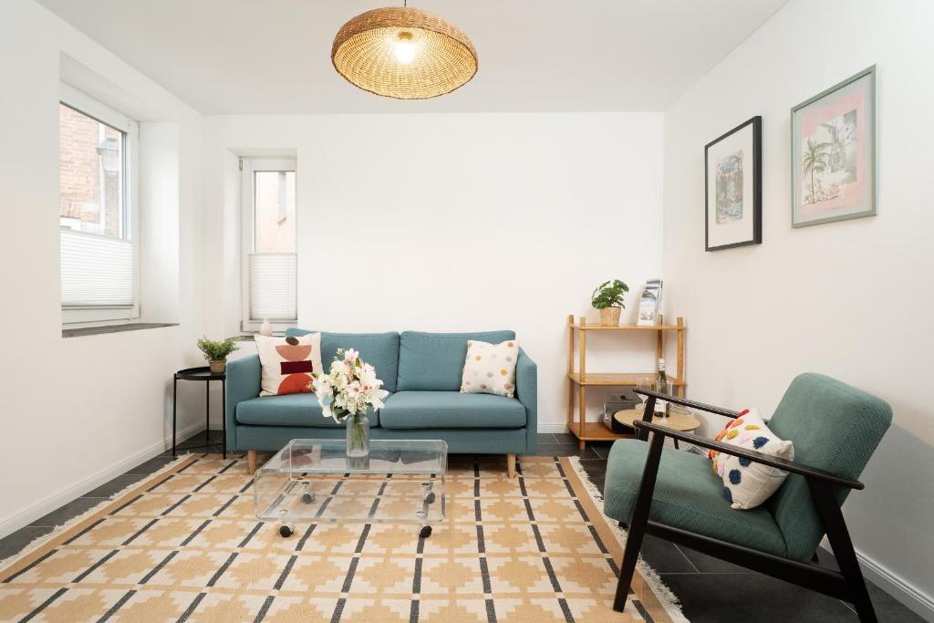 een woonkamer met een blauwe bank en twee stoelen bij Gerberhof 1 in Plön