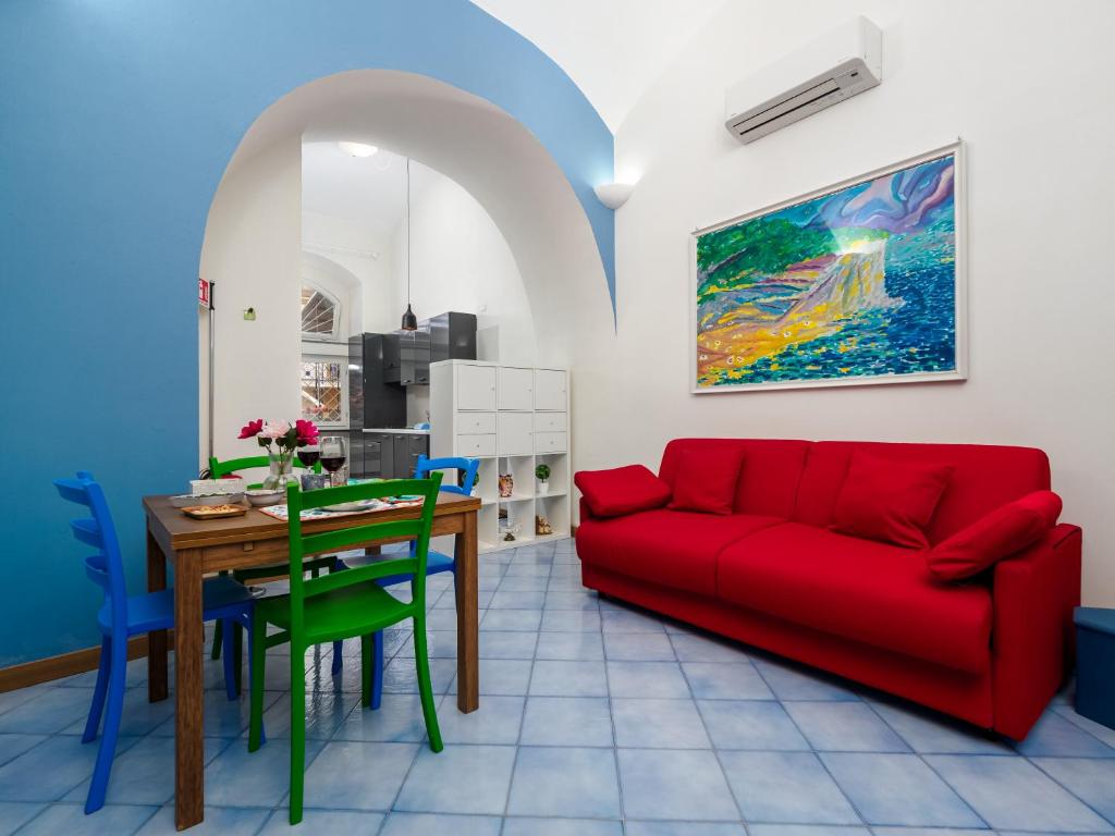 a living room with a red couch and a table at Ficus Home - De Vivo Realty in Sant'Agnello