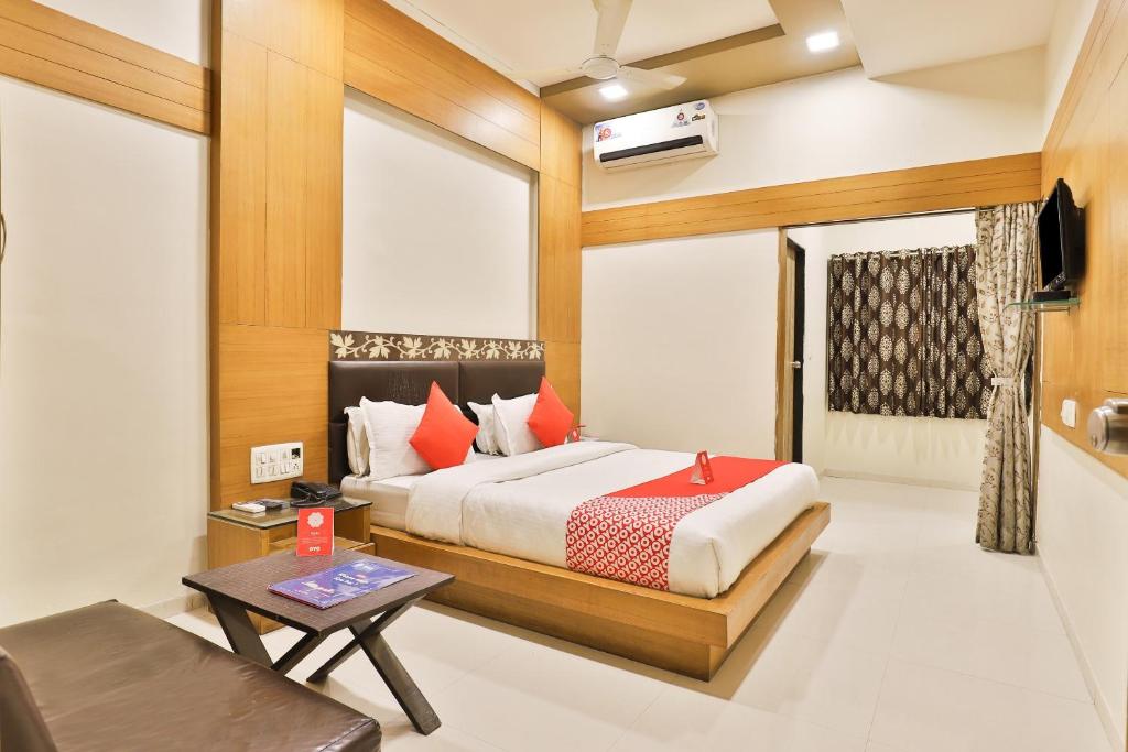 una camera da letto con un letto, un tavolo e un divano di Hotel O by OYO Shreenath a Naroda