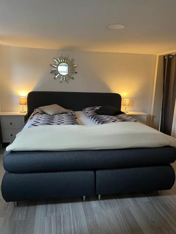 a bed in a bedroom with a mirror on the wall at CALM HOME im Erdgeschoss mit eigenem Eingang in Bad Oeynhausen