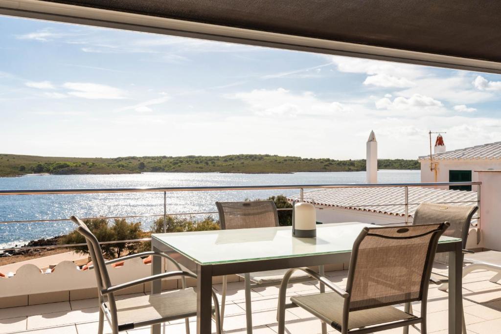 een eetkamer met uitzicht op het water bij Apartamento Tramontana 28B in Fornells
