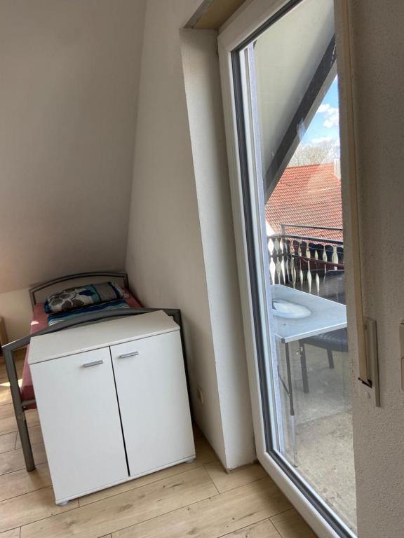 a small white refrigerator in a room with a window at GMA Apartment P8 in Lahr