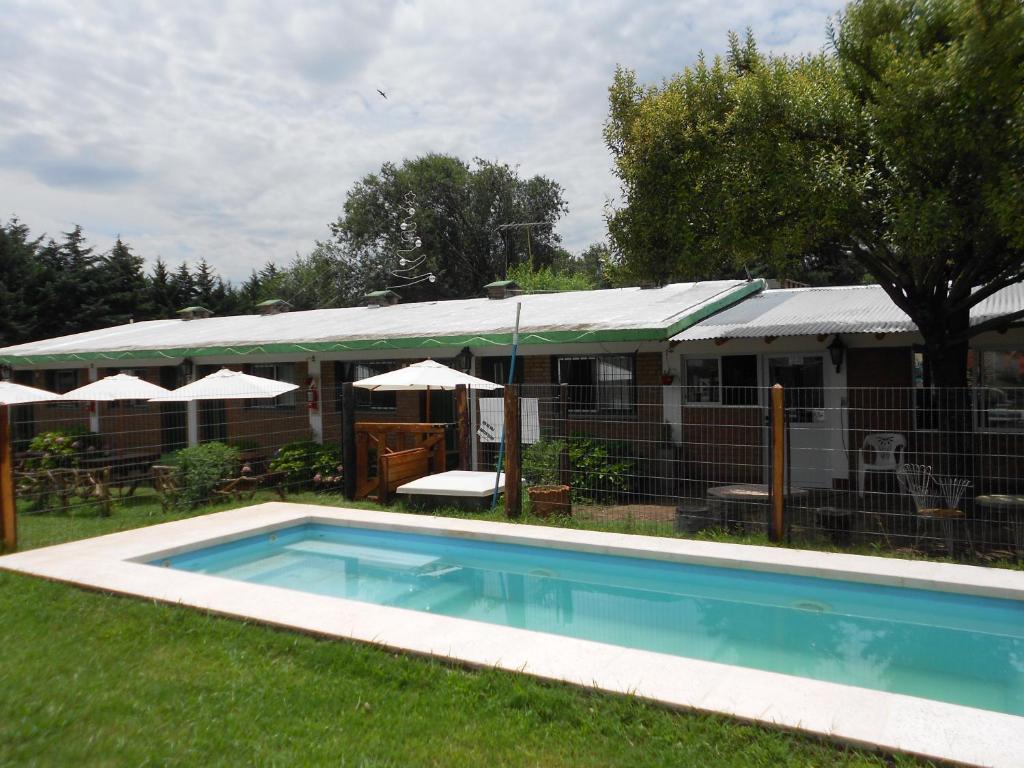 una piscina en un patio junto a una casa en Complejo Los Gringos en Villa Ciudad de América