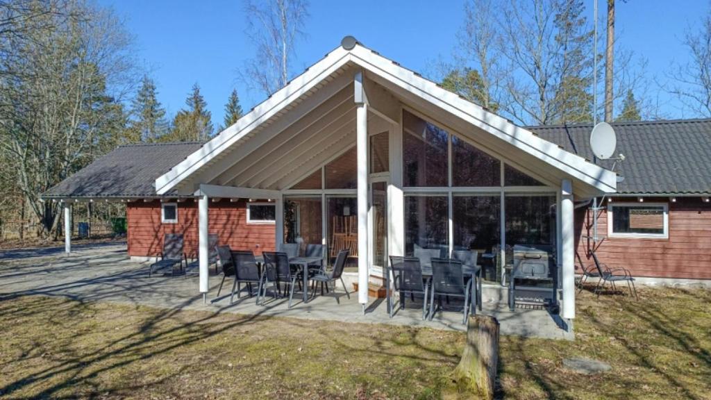 een paviljoen met stoelen en tafels op een patio bij Villavilla #244 - Öland, Sverige in Grönskog