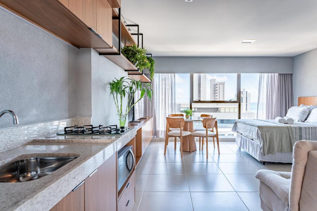 een keuken met een wastafel en een slaapkamer met een bed bij ICON - Vista Mar Boa Viagem in Recife