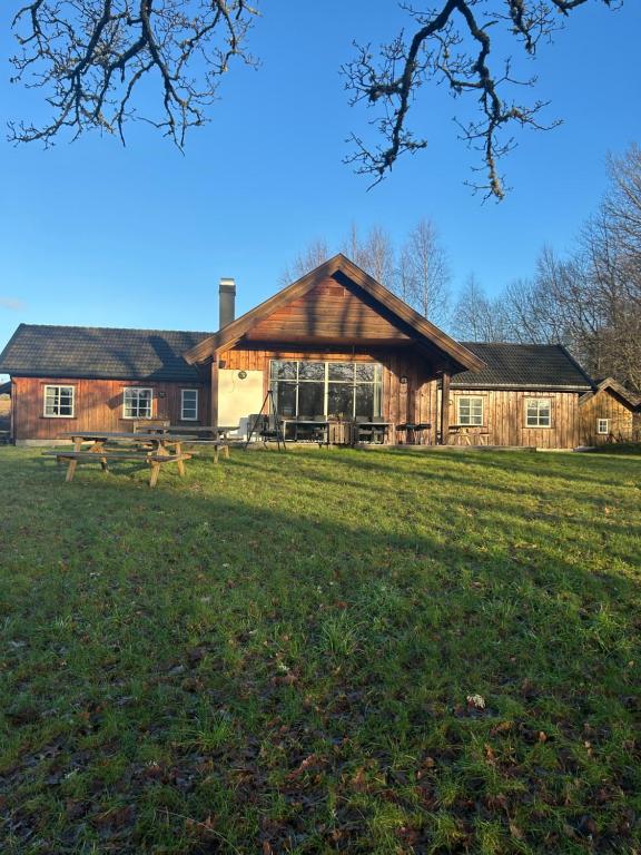 een groot houten gebouw midden in een veld bij Holmfoss Hytta in Larvik
