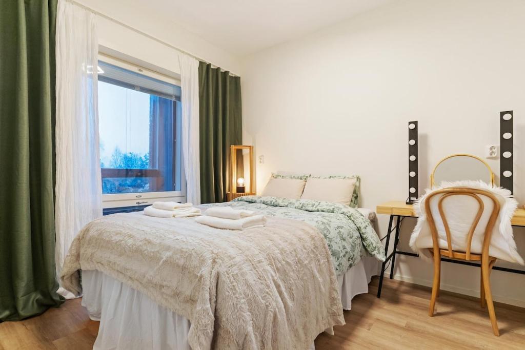 a bedroom with a bed with two towels on it at Luxury Apartment By Lapland Host in Rovaniemi