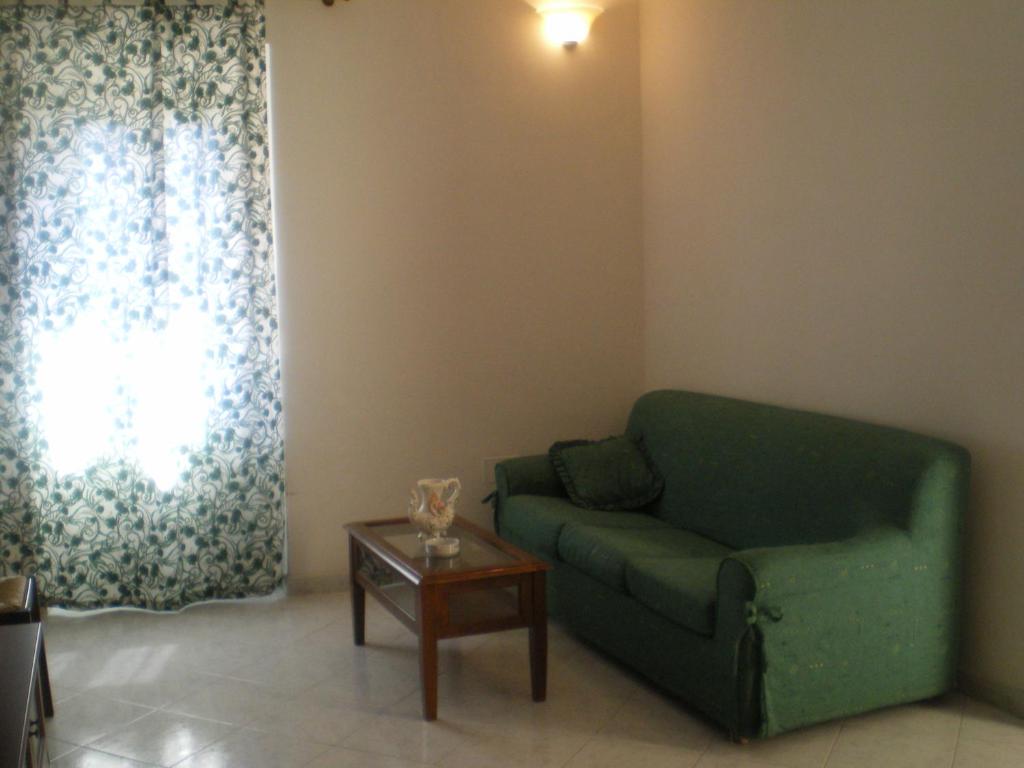 モンテヴェルディ・マリッティモにあるla ruga fioritaのリビングルーム(緑のソファ、テーブル付)