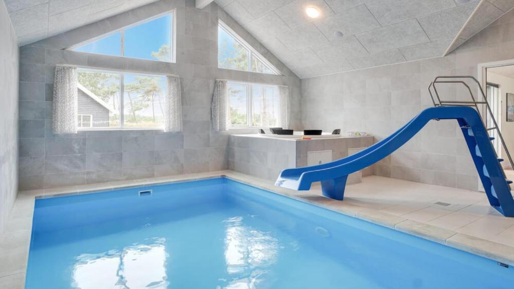 ein Schwimmbad mit einer blauen Rutsche in einem Badezimmer mit in der Unterkunft Villavilla #449 - Dueodde, Bornholm in Bedegård