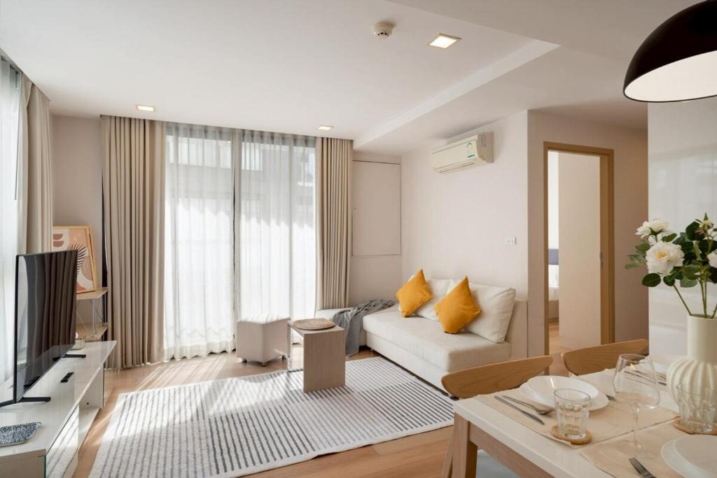 een woonkamer met een bank en een tafel bij 2BR2BA BTS Thonglor Rooftop Pool Gym BBQ Low in Bangkok