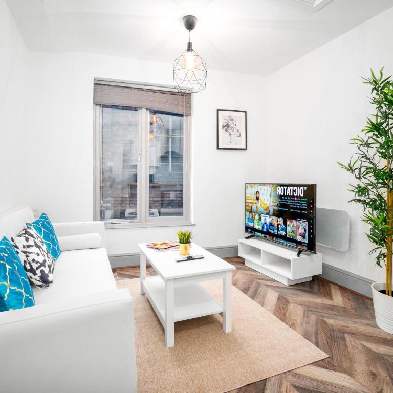 een woonkamer met een witte bank en een tv bij Cozy Apartment - Wolverhampton City Centre - Netflix 12AC in Wolverhampton