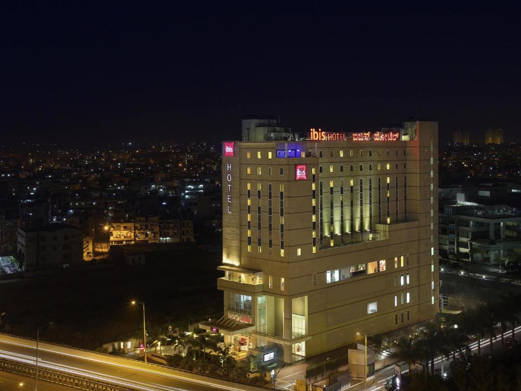 a tall building with lights on top of it at night at ibis Bengaluru Hosur Road - An Accor Brand in Bengaluru