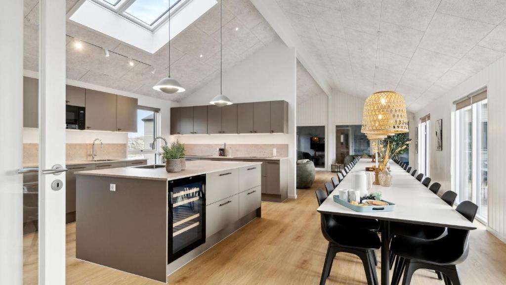 een keuken met een groot kookeiland en een eettafel bij Villavilla #910 - Marielyst, Lollandfalstermøn in Stovby
