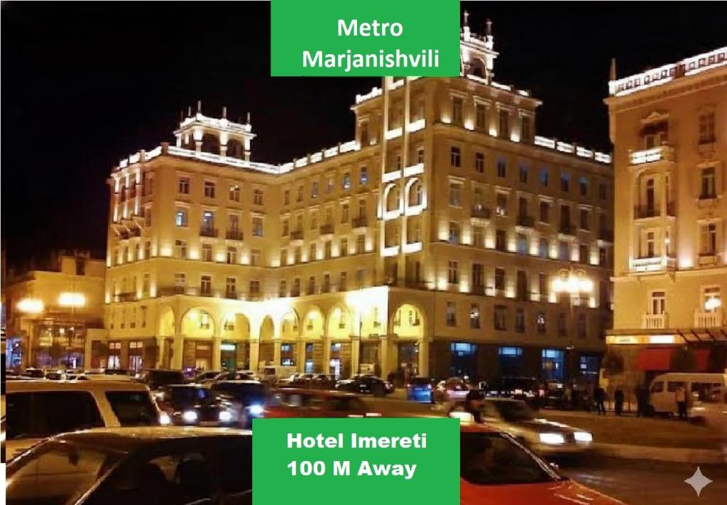 a large building with cars parked in a parking lot at Hotel Imereti - Old Tbilisi Center in Tbilisi City