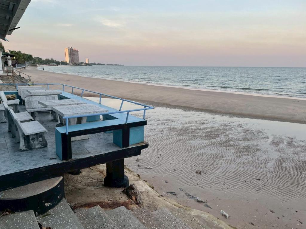 een picknicktafel op het strand naast de oceaan bij Sea Side Villa in Ban Pak Khlong Cha-am
