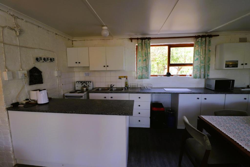 a kitchen with white cabinets and a counter top at Shalom House in Arniston
